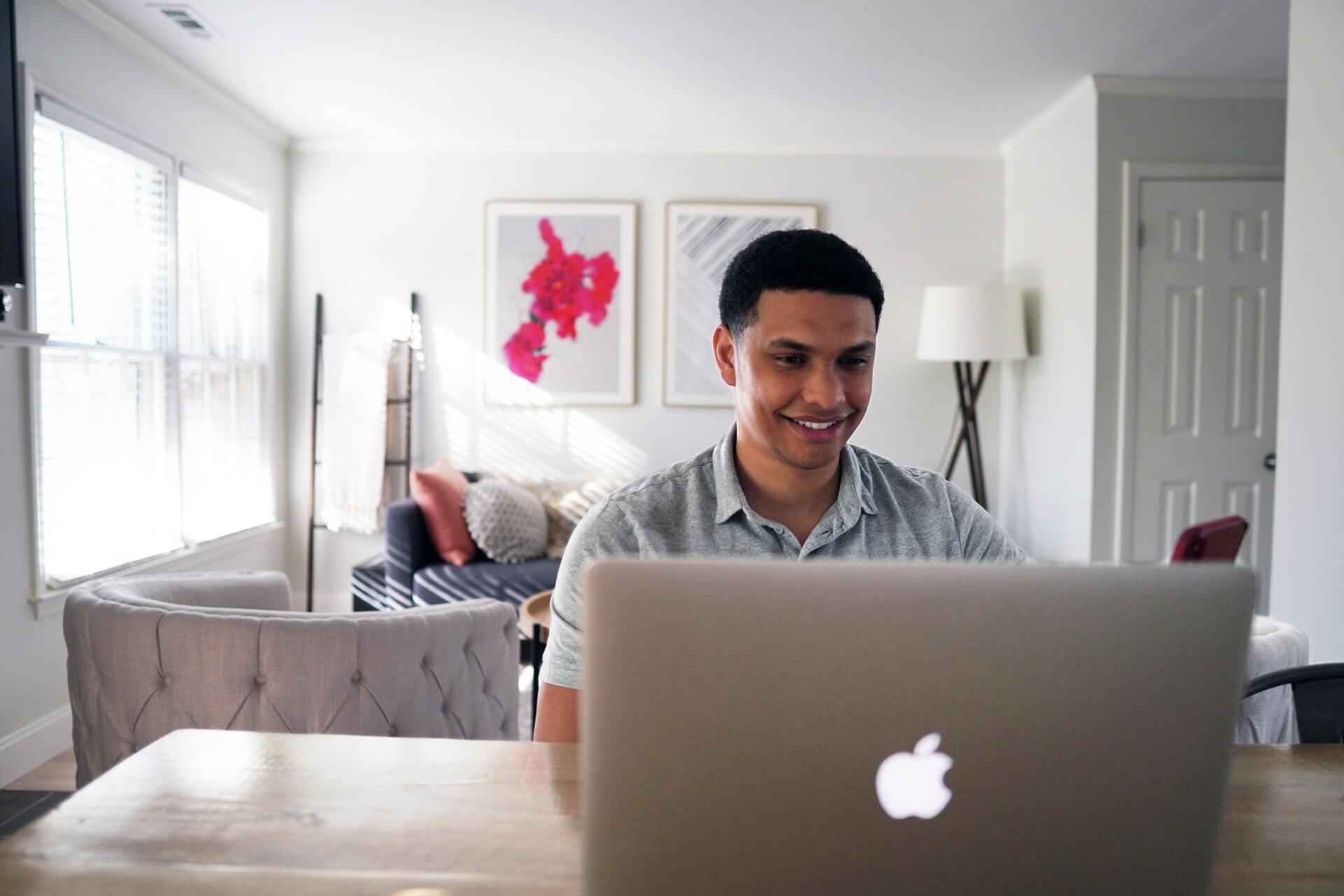 homme sourire ordinateur bureau tableau lampe